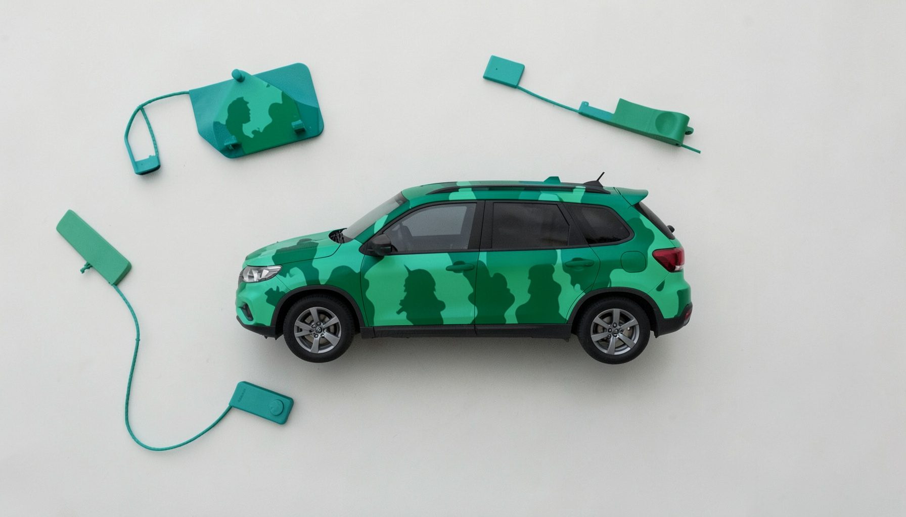 Silhouette camouflée d'un SUV compact sur route de campagne, tons verts et gris, ambiance d'essai discret.