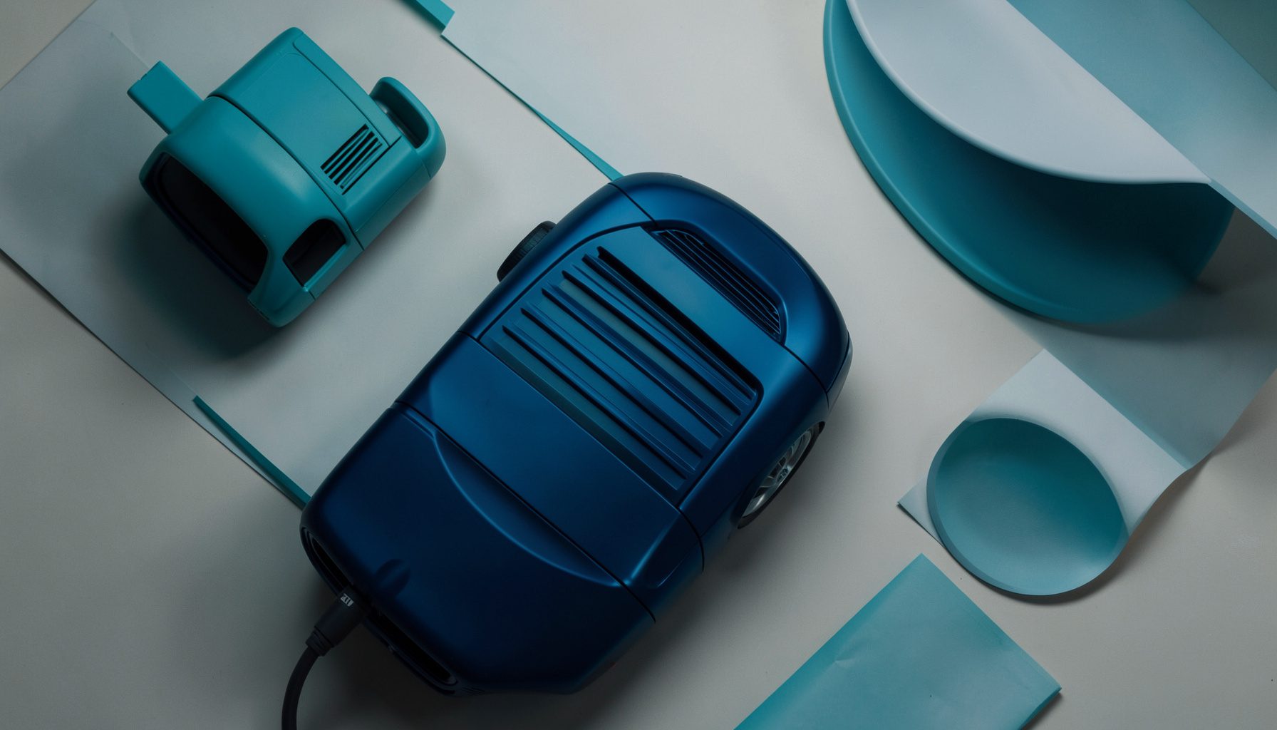 Vue rapprochée d'une calandre moderne aux lignes nettes, carrosserie bleu profond sous un éclairage de studio tamisé, ambiance premium et dynamique.