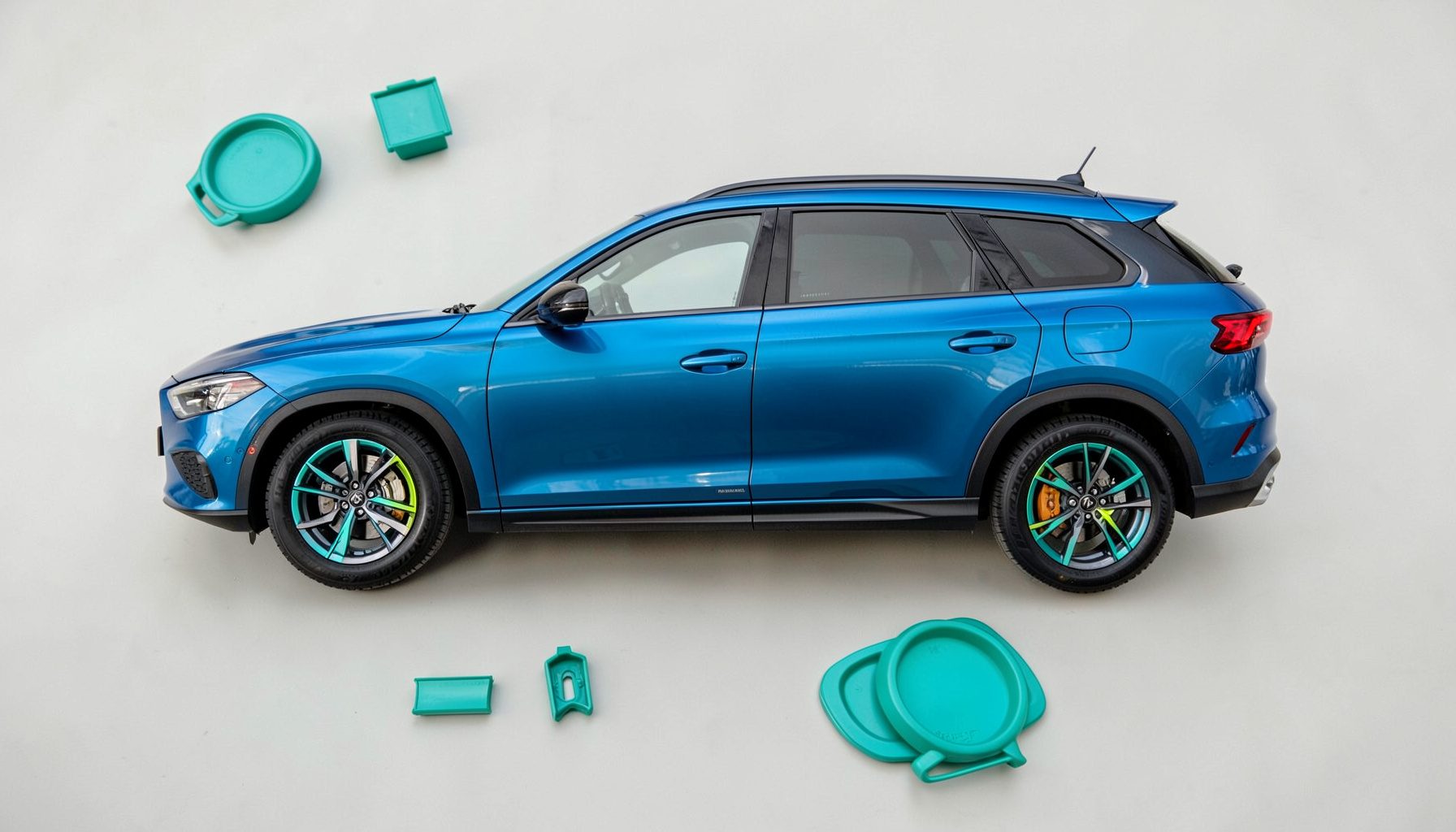 SUV urbain bleu électrique vu de profil, jantes alliage bicolores, arrière-plan urbain flou.
