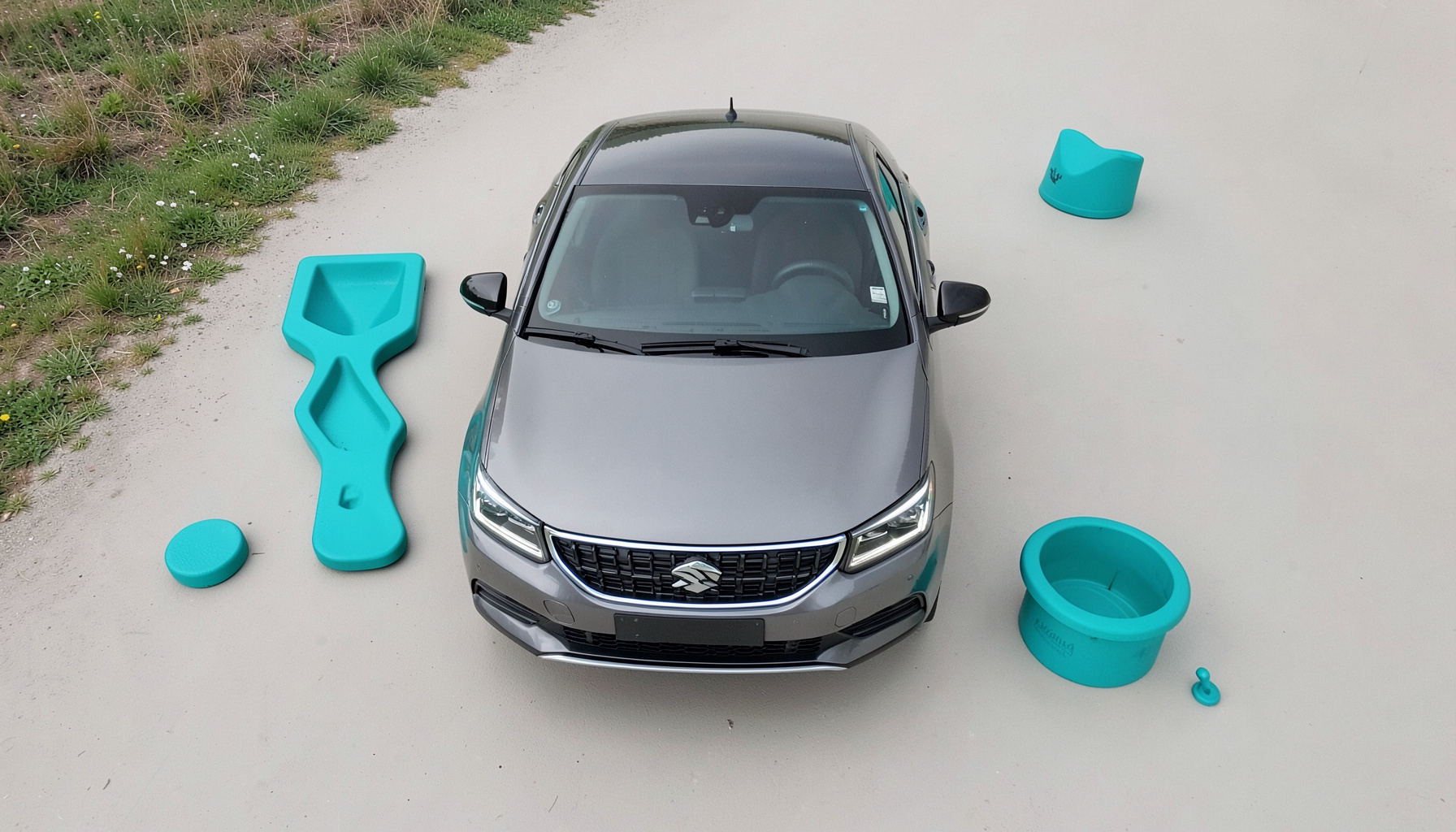 Berline compacte grise au design épuré, face avant avec signature lumineuse LED, photographiée sur une route de campagne.